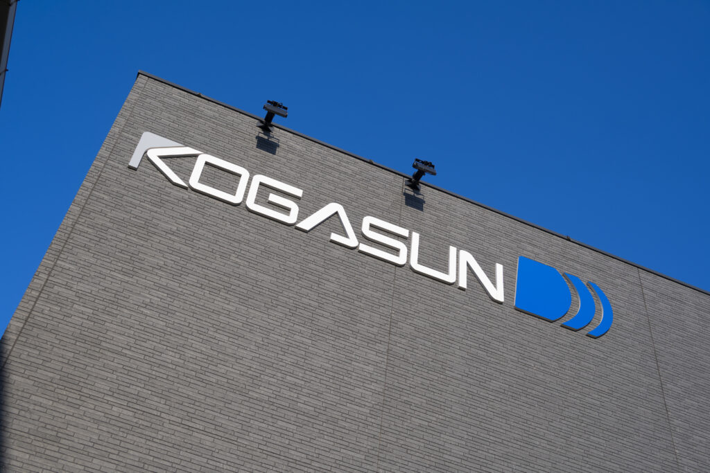 KOGASUN本社の外観｜企業ロゴと青空が映える社屋
