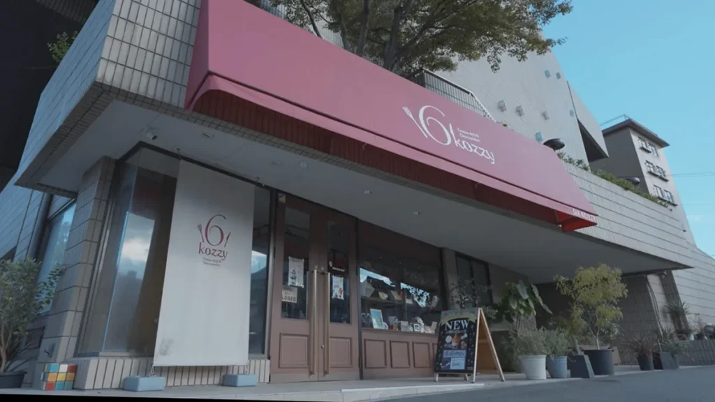 千草ホテルkozzy店舗外観|赤いテントと木目のドアが印象的な北九州市八幡のカフェ