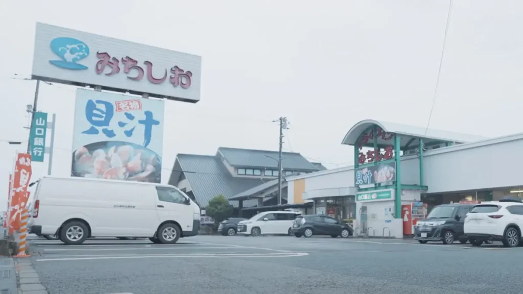 山口県の飲食店「みちしお」外観写真、大きな看板に「みちしお」と「貝汁」、駐車場に車が数台停まる風景