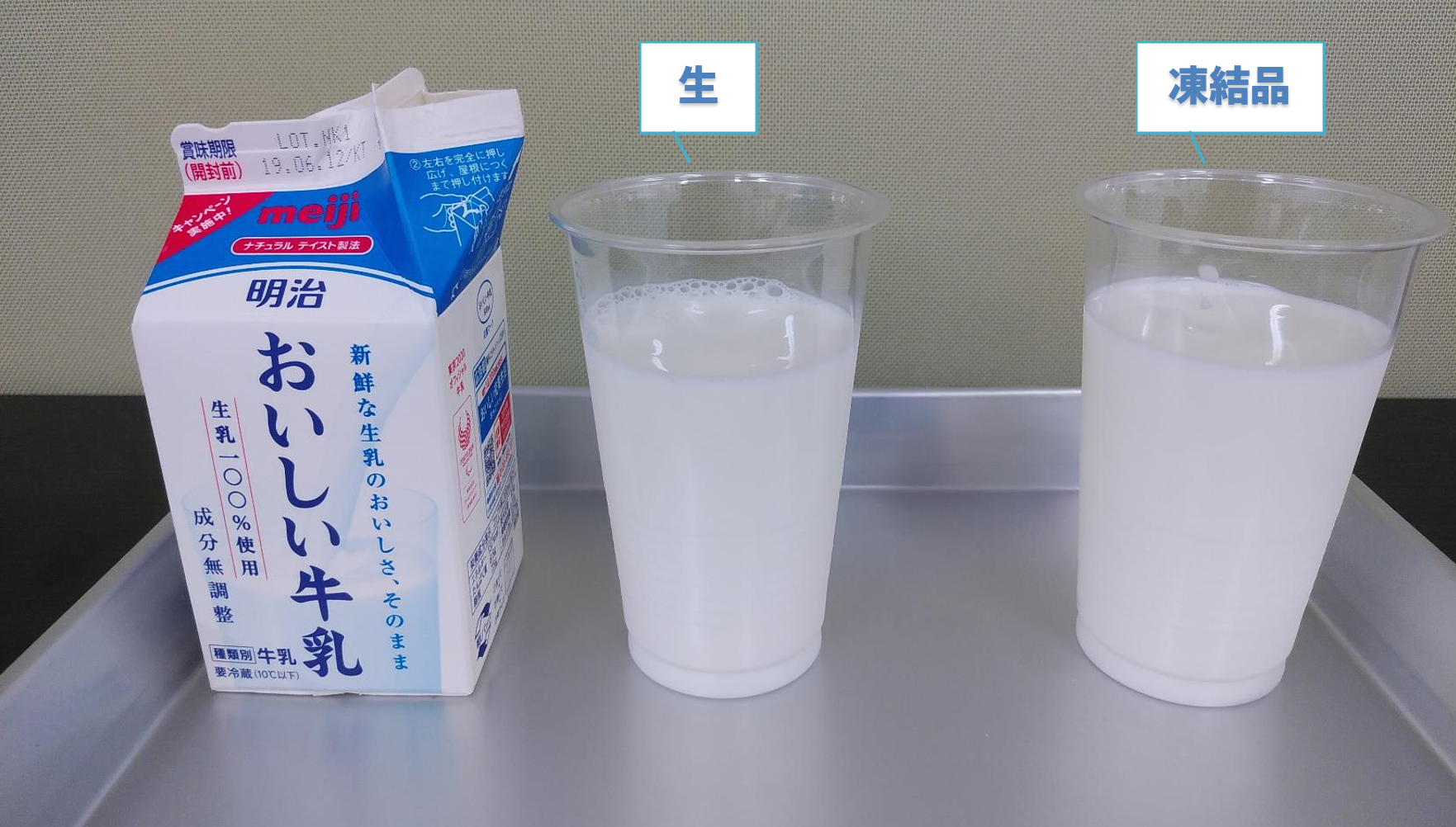 開封した牛乳の紙パックの隣に、白い牛乳を注いだ透明カップを2つ並べ、左に「生」右に「凍結品」のラベルを付けた飲み比べ。どちらも上澄みと沈殿に分かれず均一な白さ