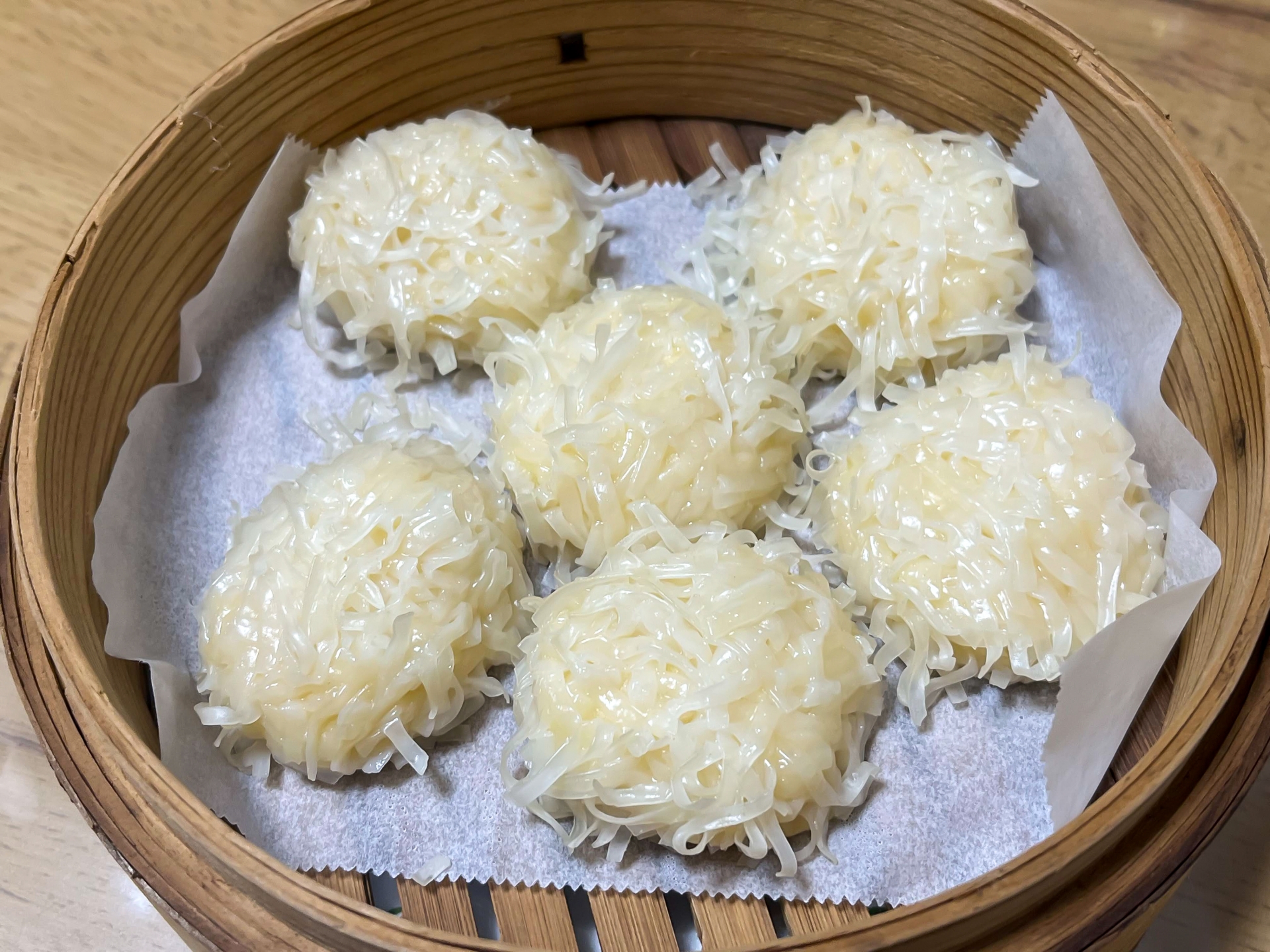 蒸籠に並べられたふっくらとしたいかしゅうまいの写真|新鮮なイカを使った海鮮点心・冷凍食品イメージ