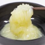 箸で持ち上げられたタコの卵の冷凍保存イメージ｜ぷるぷるとした食感と透明感のある海の幸