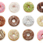 カラフルなドーナツの盛り合わせ｜白背景に並ぶ12種類のデコレーションドーナツ