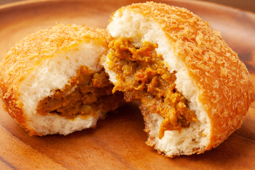 サクサク衣のカレーパンの断面。中からスパイシーなカレー餡が見える。