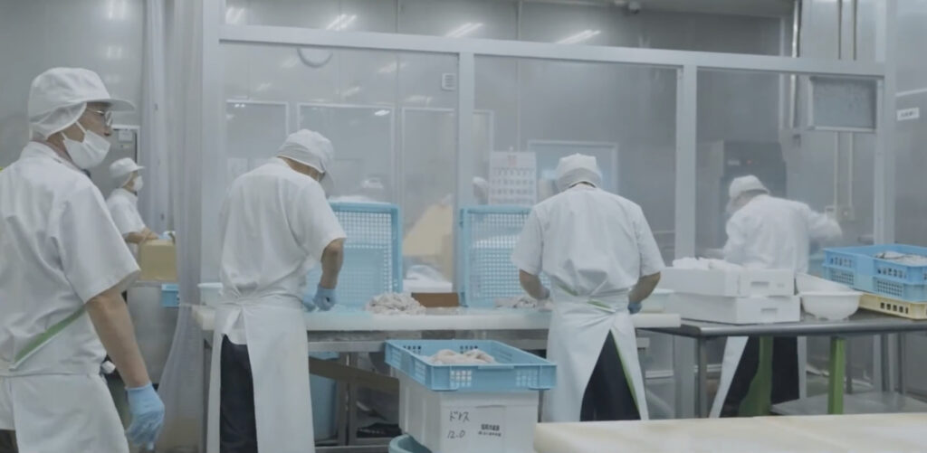 加工場で従業員が食品加工を行っている