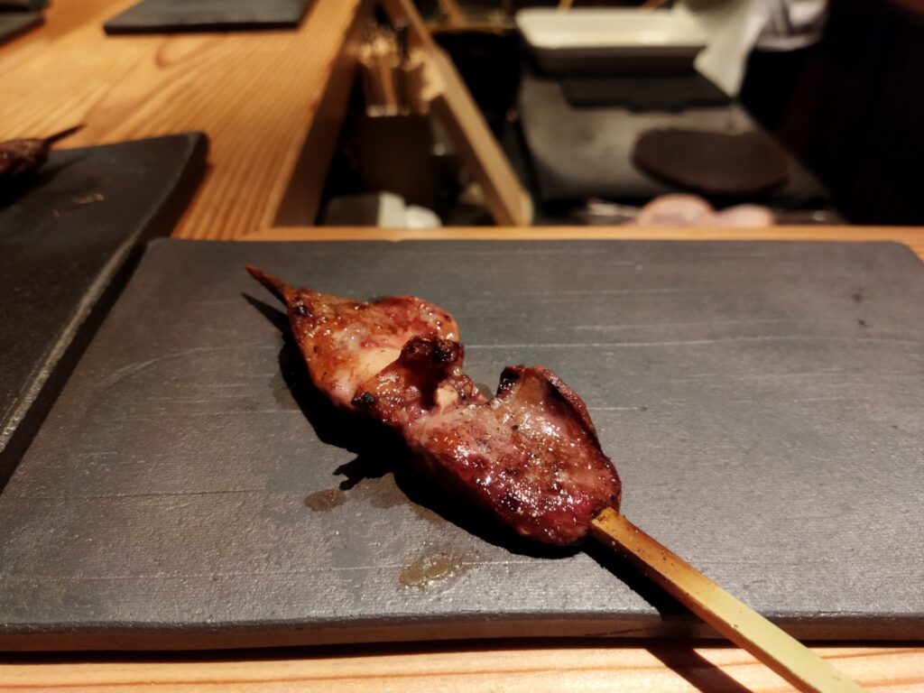 鴨ハツを串焼き調理して黒いお皿に盛り付けられた状態