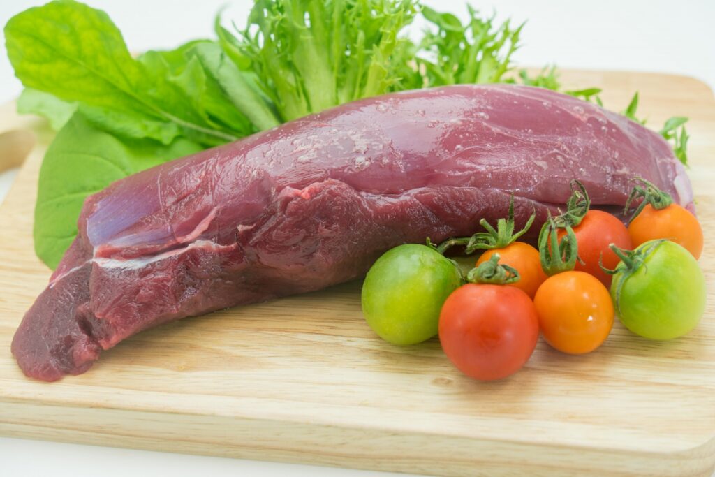 まな板に置かれた鹿のモモ肉