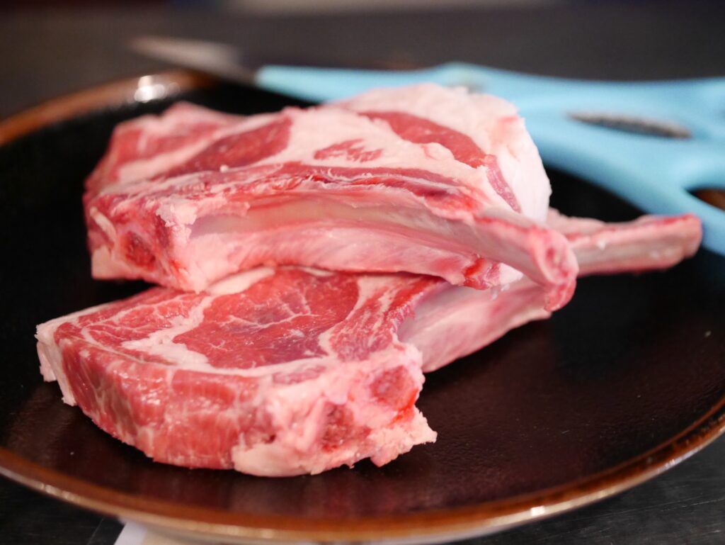 黒いお皿に盛り付けられた美味しそうなラムチョップ