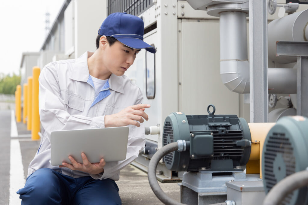 屋外機械を点検する男性作業員