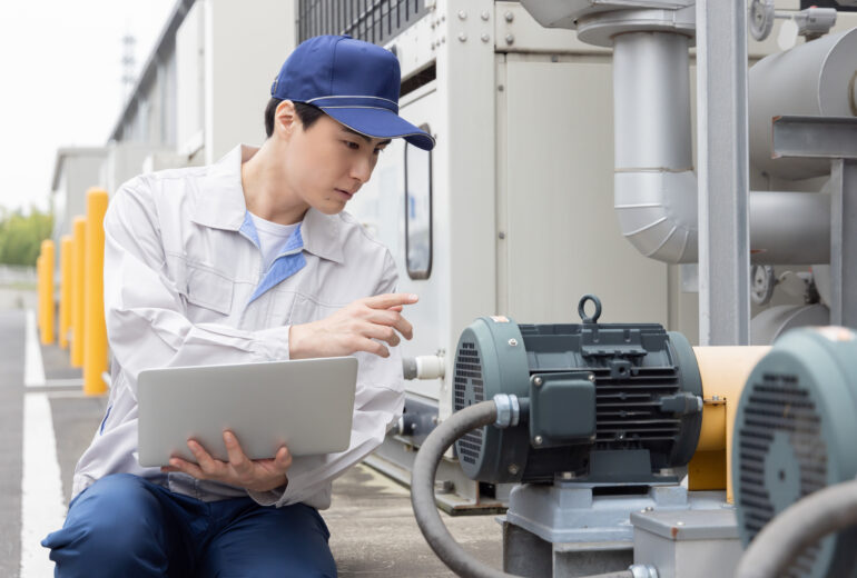 屋外機械を点検する男性作業員