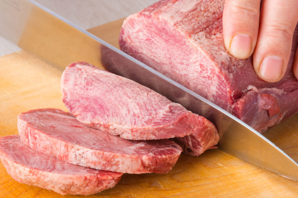 牛タンブロックをスライトカットしている