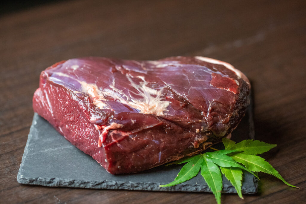 黒いお皿の上に盛られた大きな鹿肉の塊