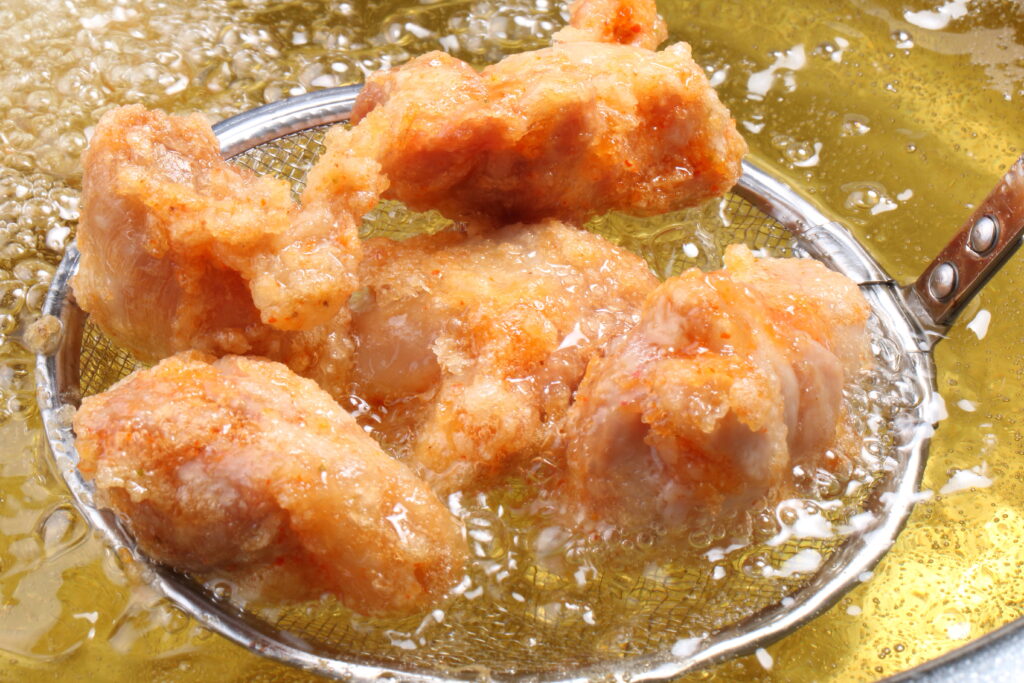 油から取り出した揚げたての唐揚げ