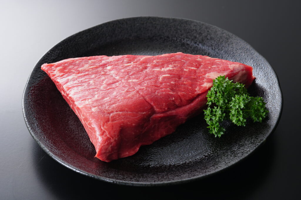 黒いお皿に盛り付けられた牛モモ肉の塊