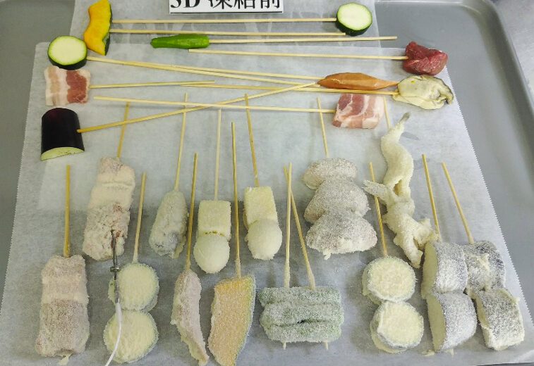 トレーの上に並べられた冷凍前の串揚げ