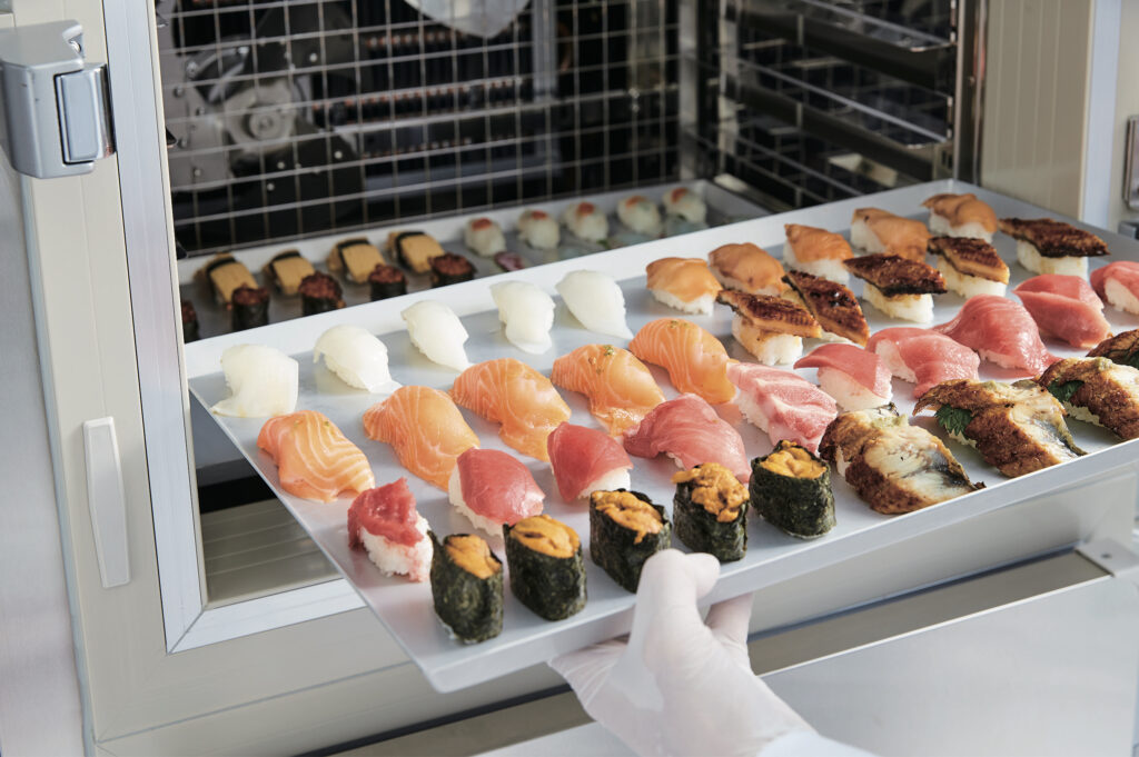 急速冷凍機に寿司を投入している