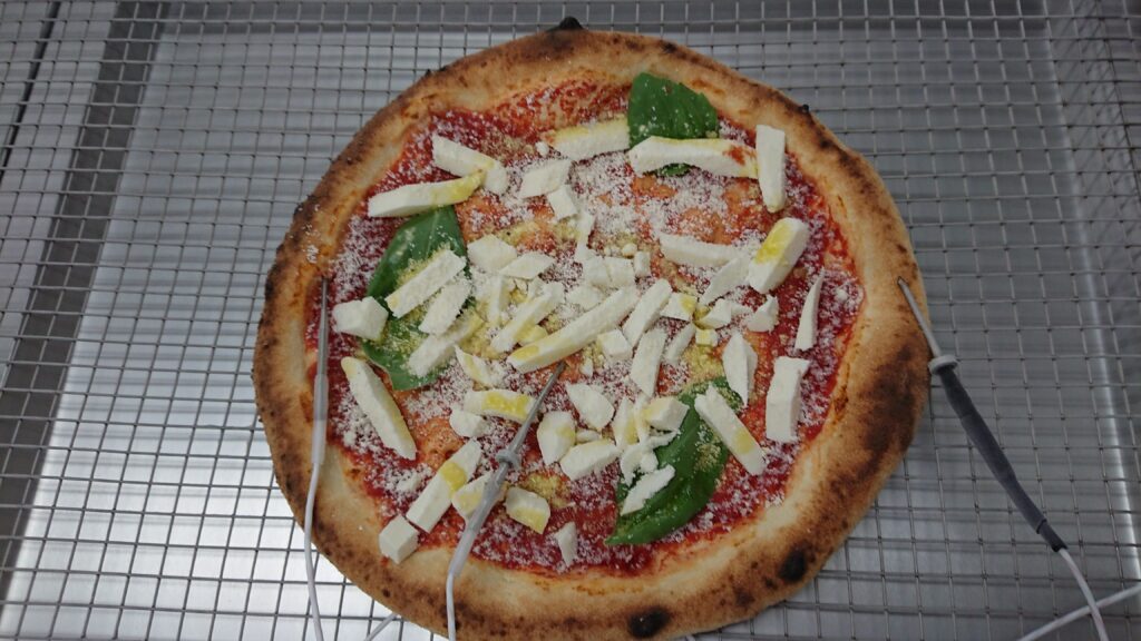 急速冷凍されたトレーにのせられた焼成前のピザ