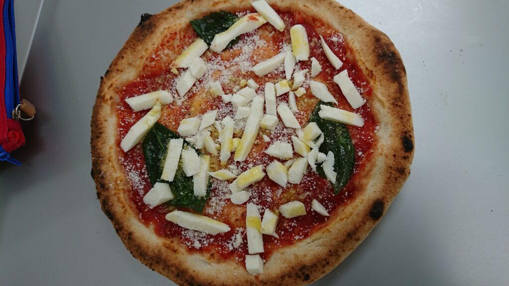 トレーにのせられた焼成前のピザ