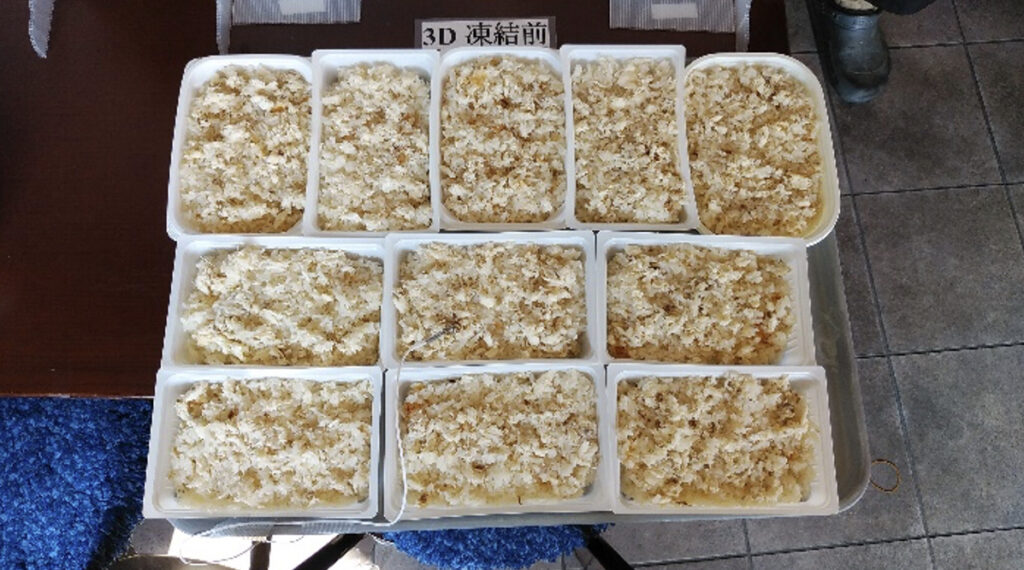 トレーに満タンに敷き詰められた炊き込みご飯パック（冷凍前）