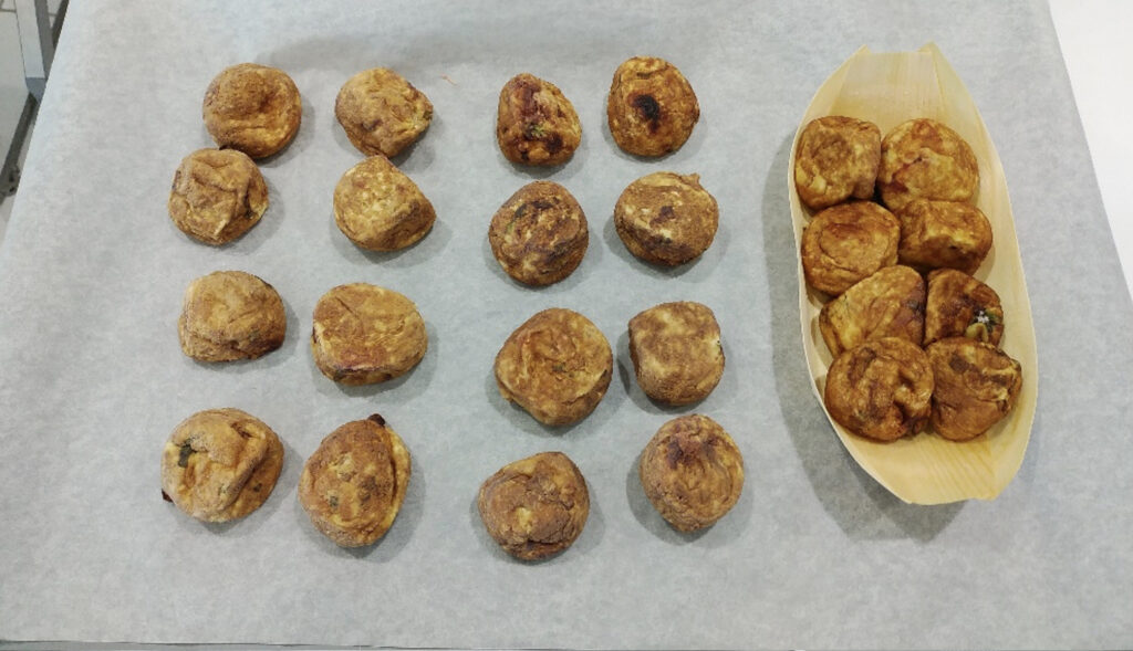 トレーの上に置かれたたくさんの出来立てのたこ焼きが急速冷凍された状態