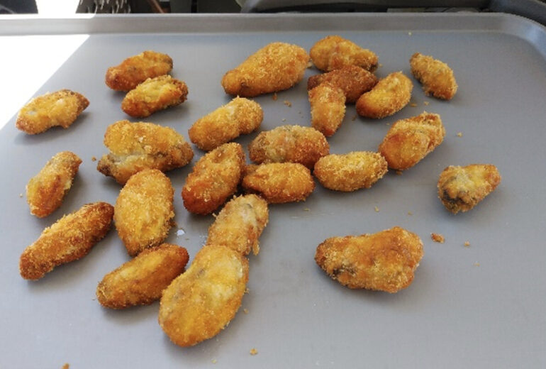 トレーに並べられた揚げたての牡蠣フライ