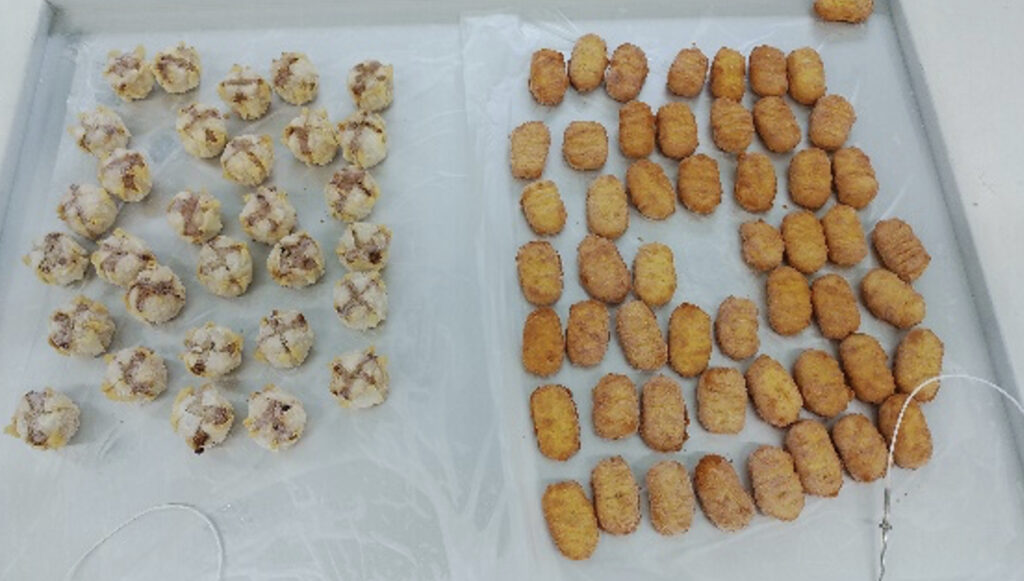 トレーに並べられた急速冷凍後のしゅうまいとチキンナゲット