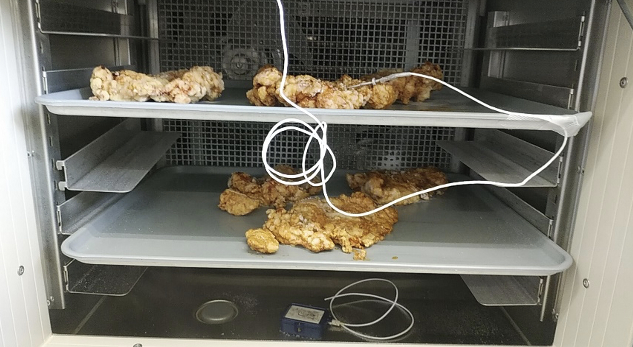 庫内で上下2段のトレーにチキン南蛮を並べ、白い温度センサーのコードが食品へ取り付けられている様子
