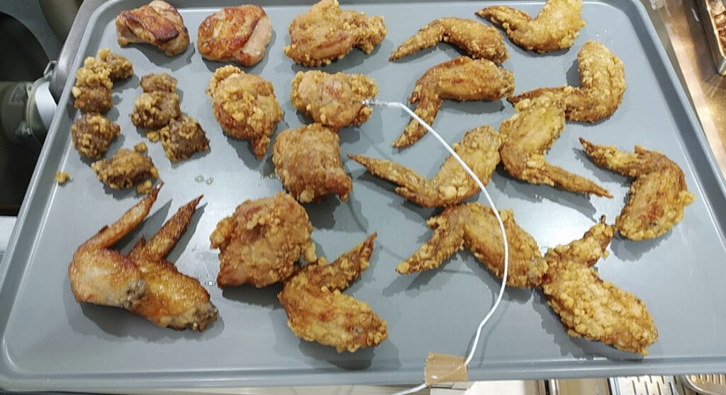 トレーにたくさん置かれた揚げたての唐揚げ