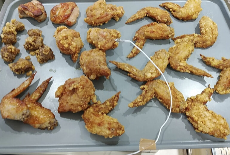 トレーにたくさん置かれた揚げたての唐揚げ