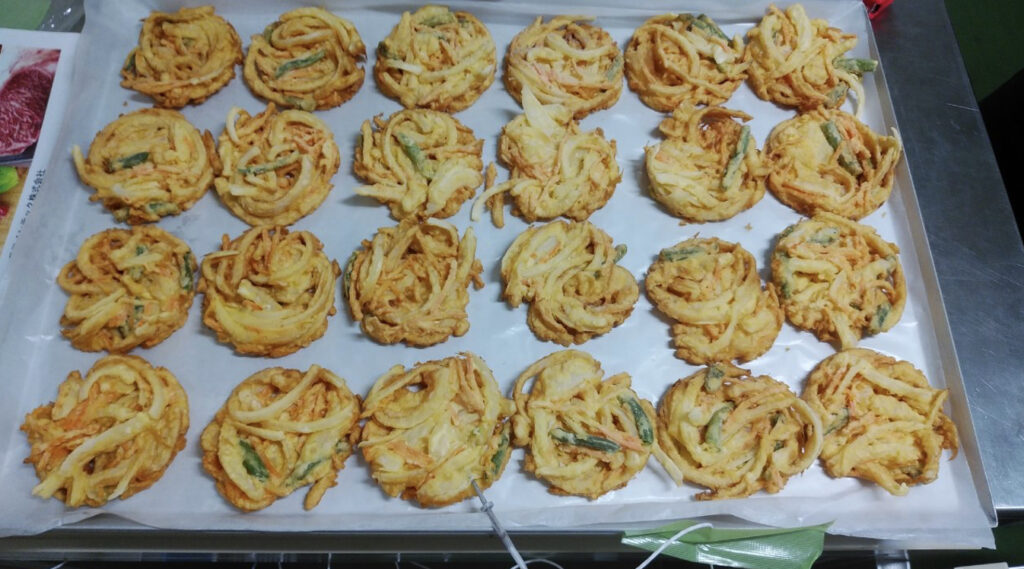 急速冷凍されたトレーに並べられたたくさんのかき揚げ