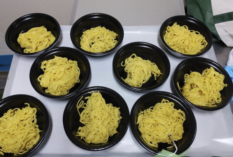 トレーに並べられた容器に入ったたくさんの中華麺