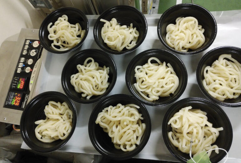 トレーに並べられた容器に入ったたくさんのうどん