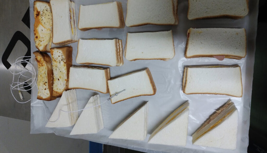 急速冷凍加工されたトレーに並べられたたくさんのサンドイッチ