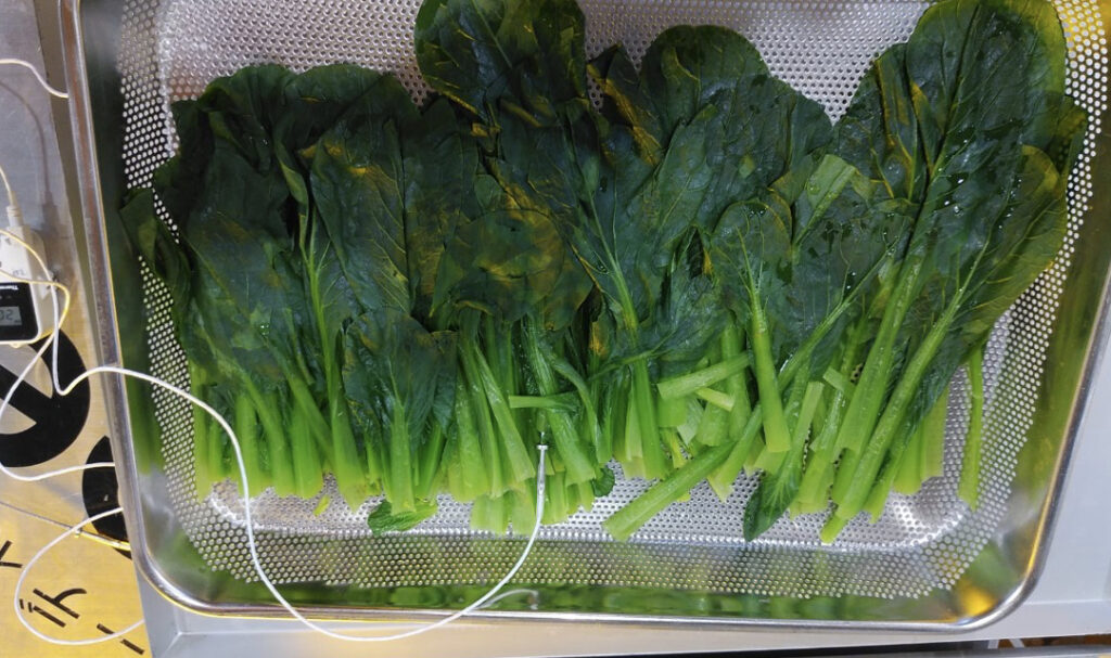 トレーに盛り付けられたボイル後のほうれん草