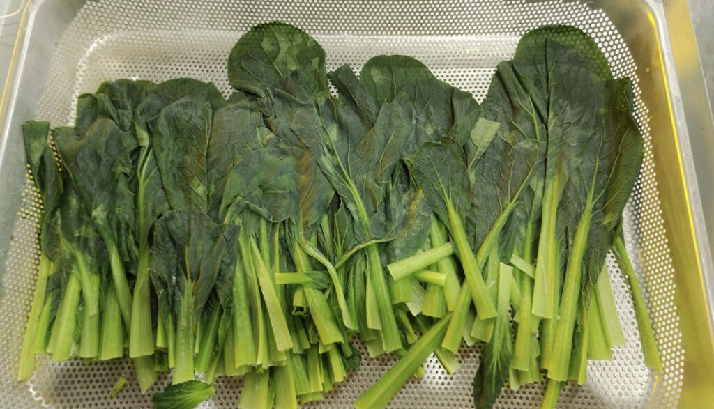 急速冷凍されたトレーに盛り付けられたボイル後のほうれん草