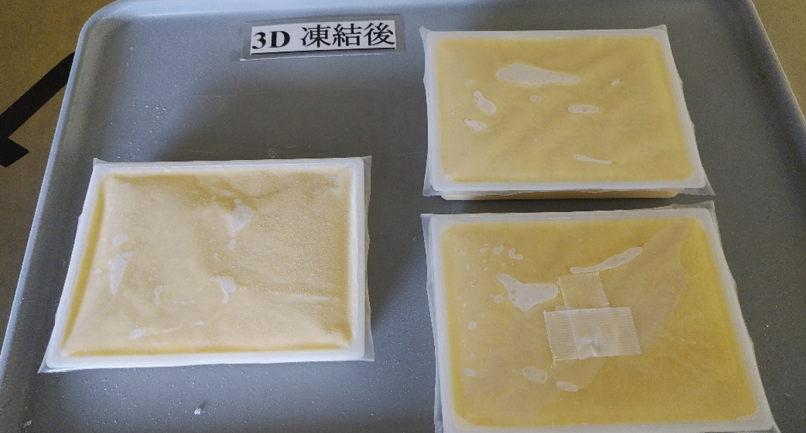 アルミトレーに並べた凍結後の黄色いごま豆腐入り四角形容器3個。右下の容器に温度センサーを固定していた透明テープが残り、左上に「3D 凍結後」の表示がある