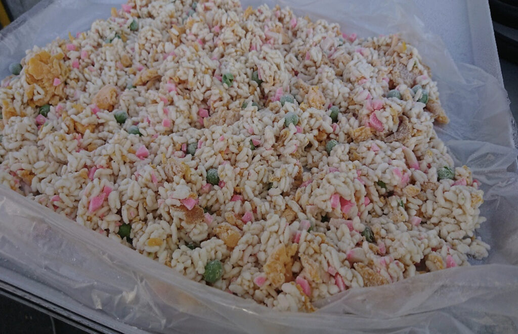 トレーの上にたくさん乗った急速冷凍された炒飯