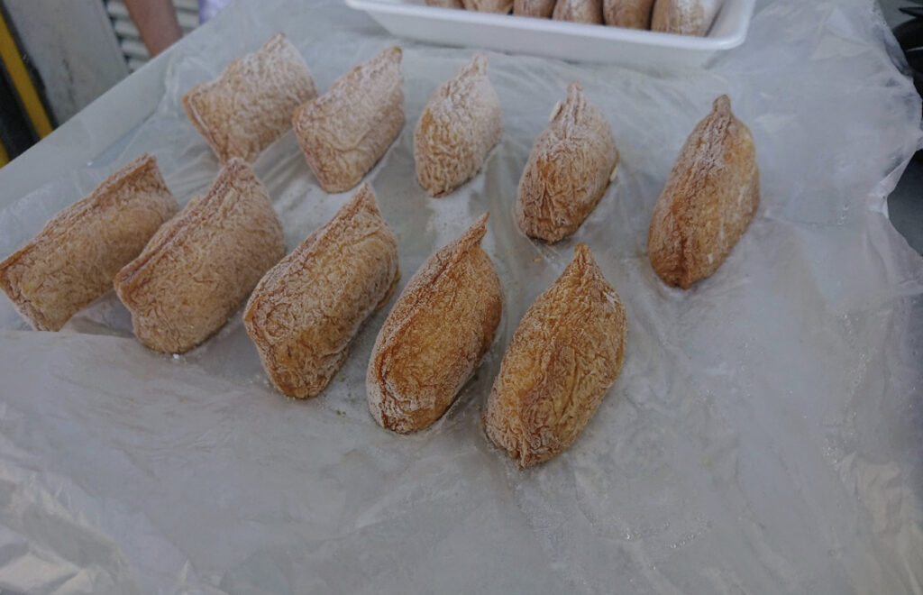 急速冷凍されたトレーの上にたくさん乗った稲荷寿司（いなり寿司）