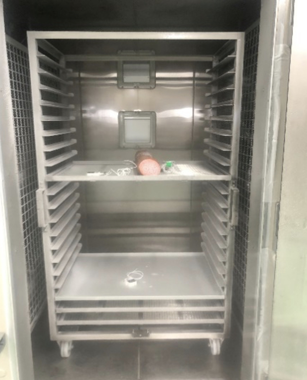 急速冷凍機の中でトレイの上に置かれたロースハムブロックがテンパリングされている