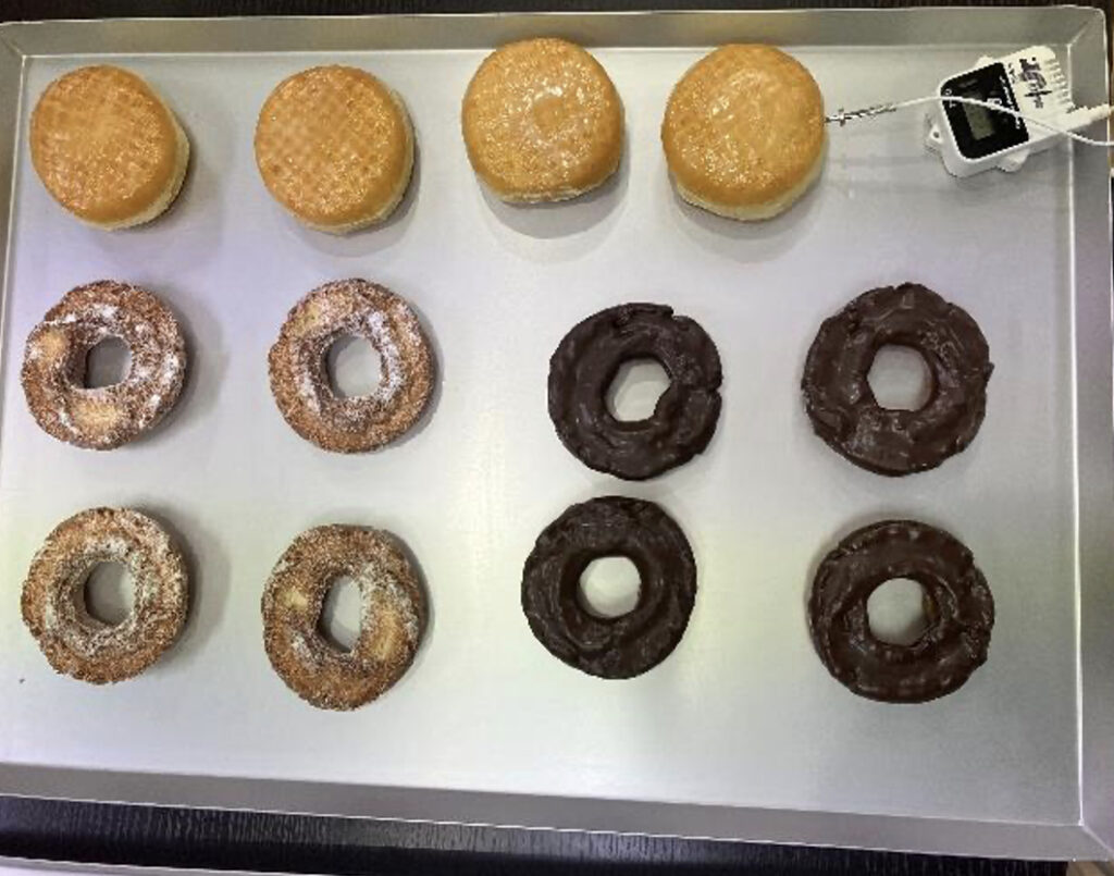 トレーにのせられた冷凍前のドーナツ