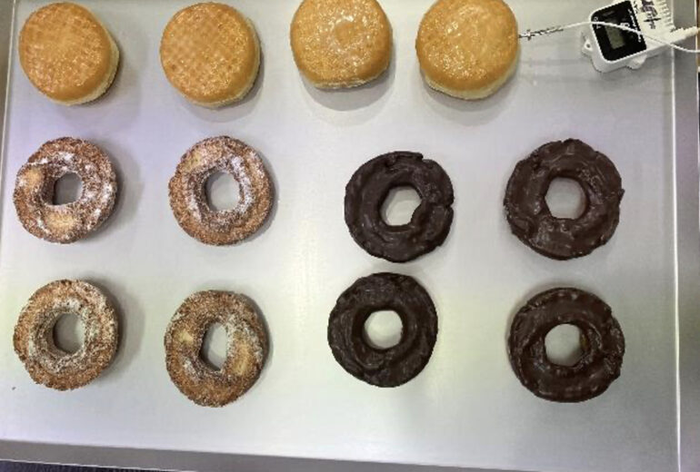 トレーにのせられた冷凍前のドーナツ