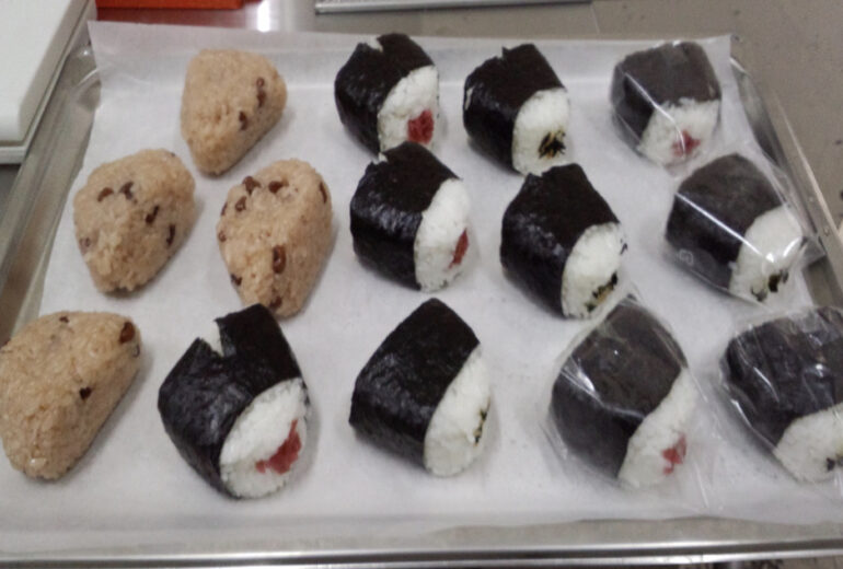 トレーの上に載せられた赤飯おにぎりと梅おにぎり
