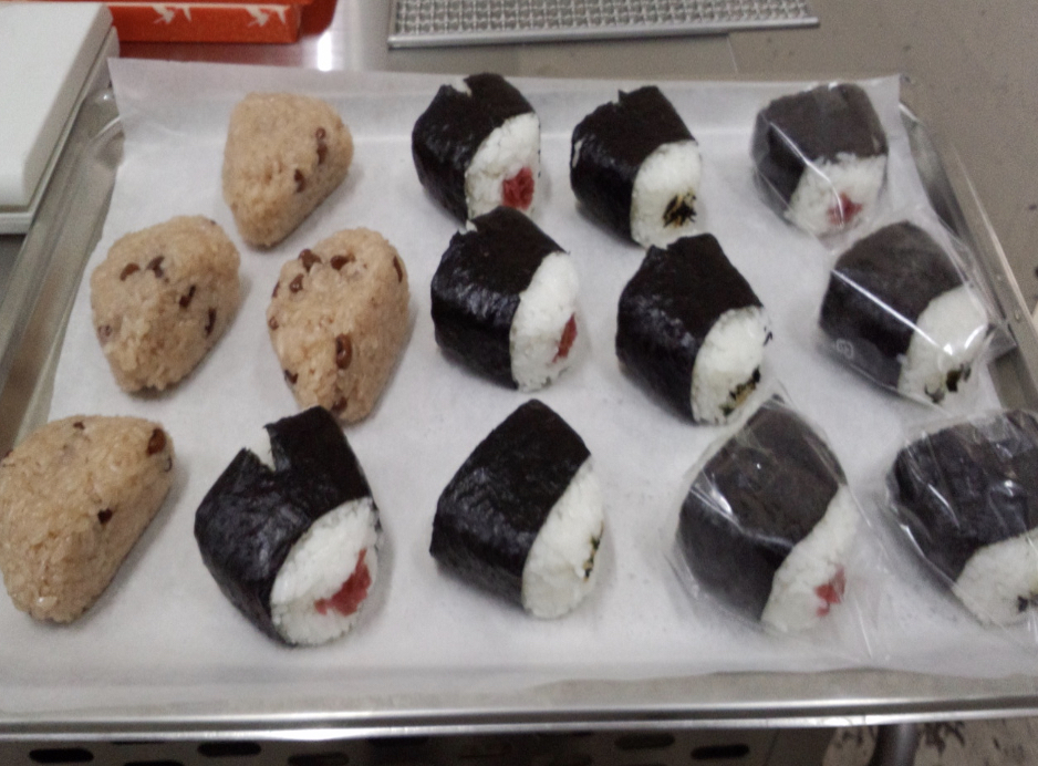 トレーの上に載せられた赤飯おにぎりと梅おにぎり