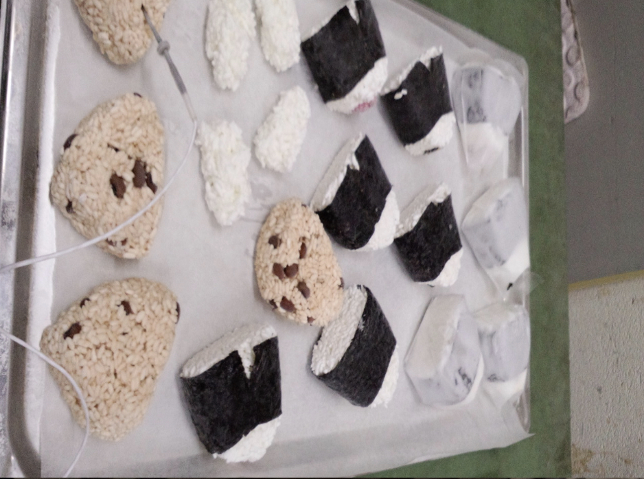 急速冷凍されたトレーの上に載せられた赤飯おにぎりと梅おにぎり