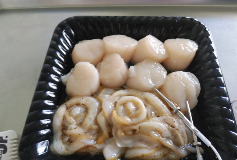 黒いトレイの中に入った生ホタテ
