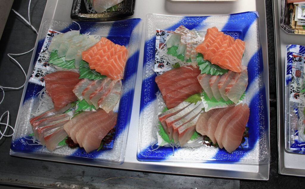 トレーの上にたくさんの刺身のトレーパックがのっている