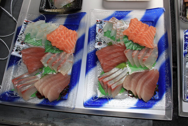 トレーの上にたくさんの刺身のトレーパックがのっている