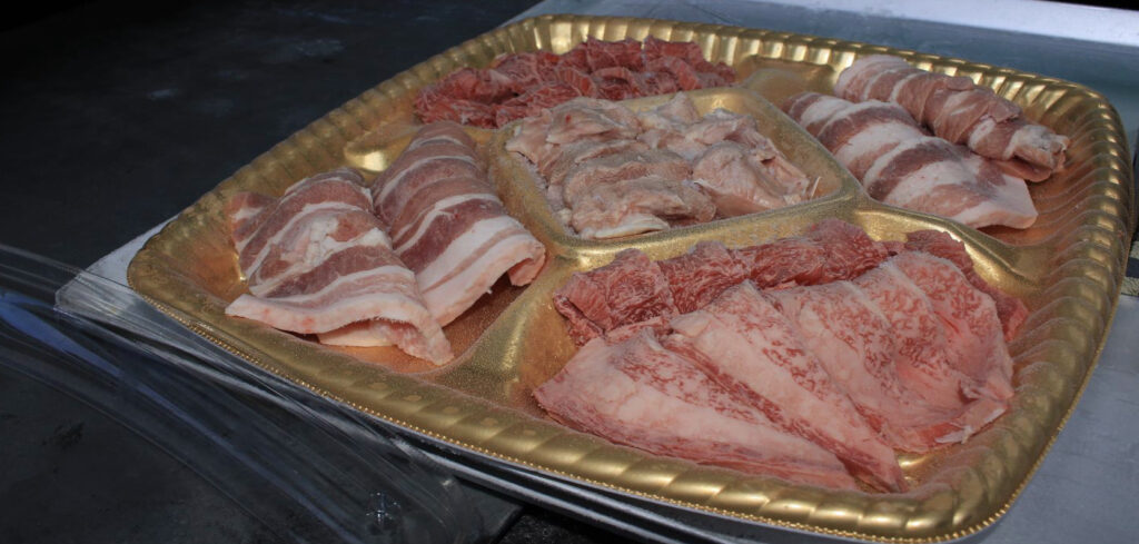 トレイの上にもられた様々なお肉の盛り合わせパックの急速冷凍後の状態