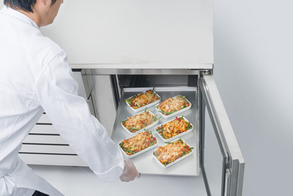 レストランの厨房でシェフがブラストチラーを活用し、調理の効率化を図っている様子。