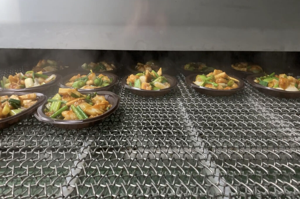 トンネルフリートンネルフリーザーのベルト上に製品が流れているザーのベルト上に製品が流れている